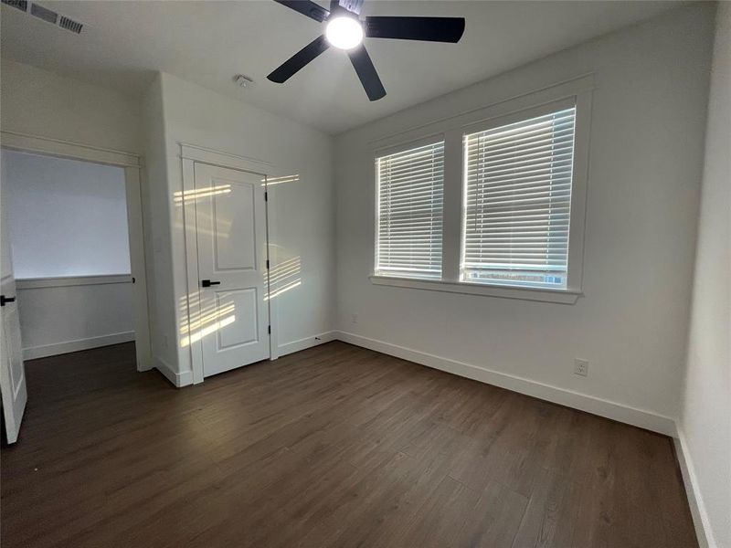 Unfurnished bedroom featuring dark wood finished floors, a ceiling fan, and a closet