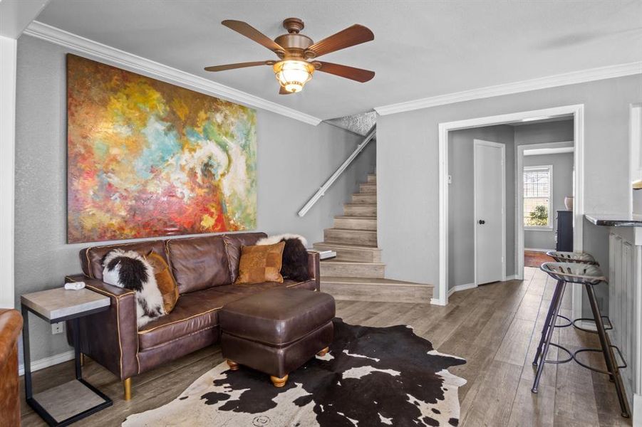 Living room featuring ceiling fan, light hardwood / wood-style flooring, and crown molding