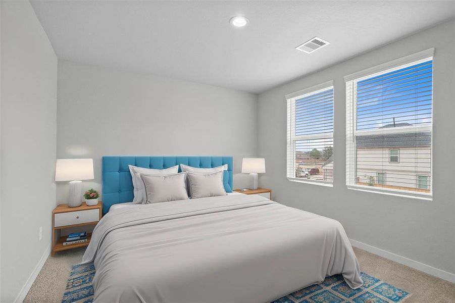 This secondary bedroom features high ceilings, recessed lighting, custom paint, plush carpet, and large windows with privacy blinds!