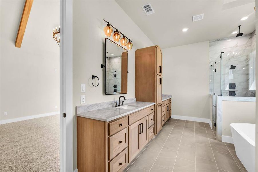 Full bathroom featuring a marble finish shower, vanity, a freestanding bath, light tile patterned floors, and recessed lighting