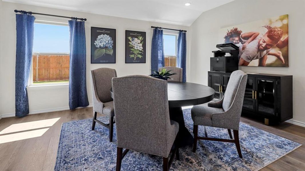 Dining area with wood finished floors and vaulted ceiling