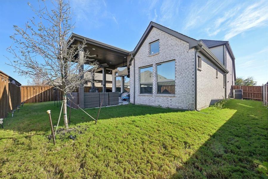 Back of property with a yard, central AC unit, and an outdoor hangout area