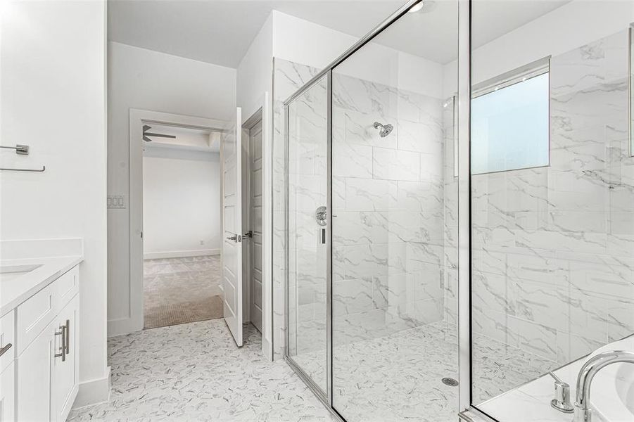 Bathroom with a marble finish shower and vanity