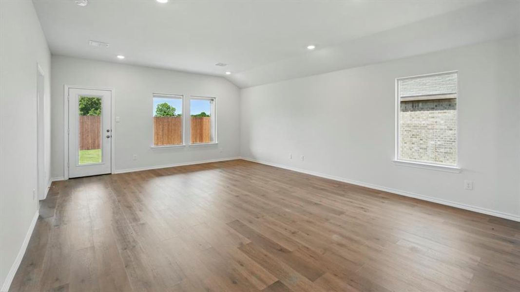 Spare room with light wood-style floors, recessed lighting, and lofted ceiling