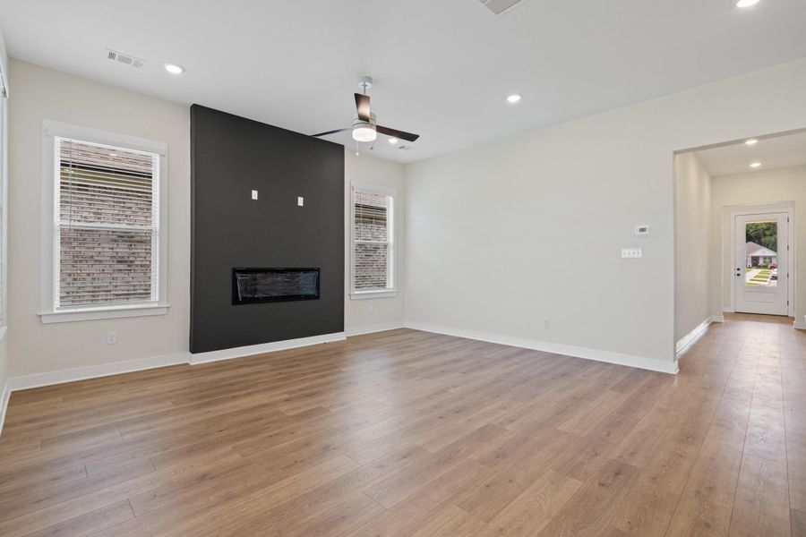 Open-concept living area featuring wood-finish flooring, recessed lighting, and a modern ceiling fan Open-concept living area featuring wood-finish flooring, recessed lighting, and a modern ceiling fan