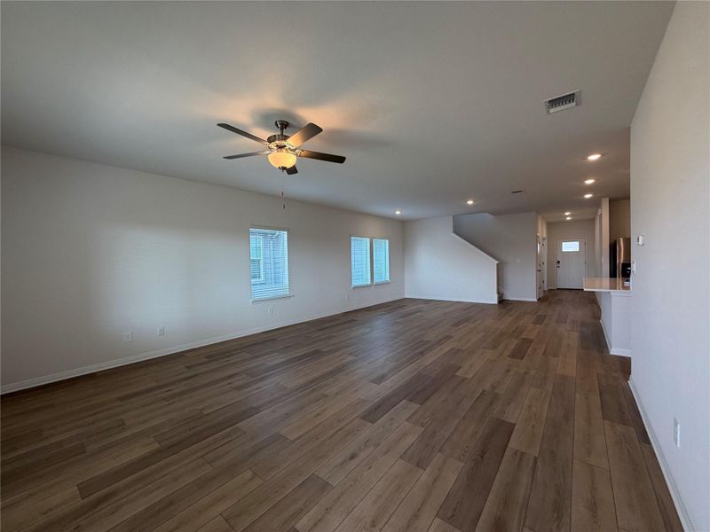 Unfurnished living room featuring dark wood-type flooring, recessed lighting, and a ceiling fan