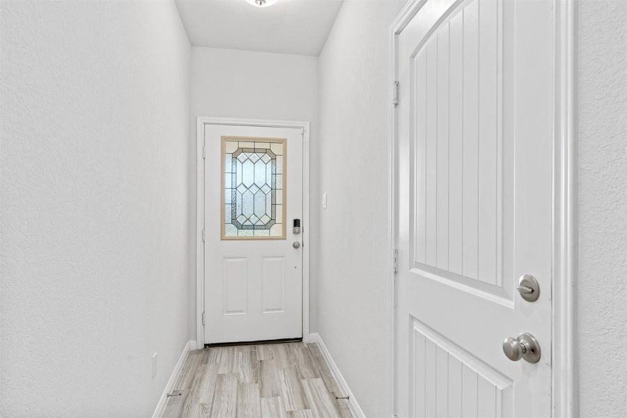 Entryway with baseboards and wood finished floors