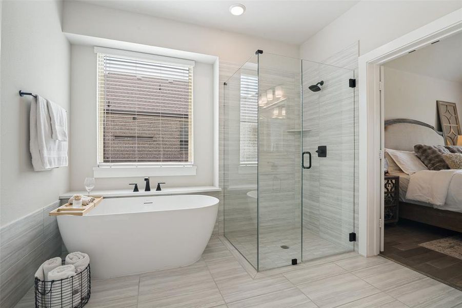 Freestanding soaking tub and glass-enclosed shower with matte black fixtures