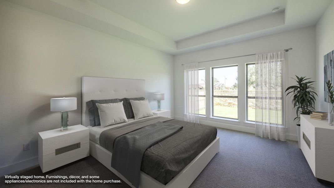 Carpeted bedroom featuring a raised ceiling