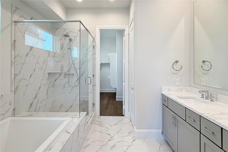 Progress photo of actual unit. Large drop-in tub with separate walk-in shower with semi-framless glass enclosure, dual vanity and spacious walk-in closet.