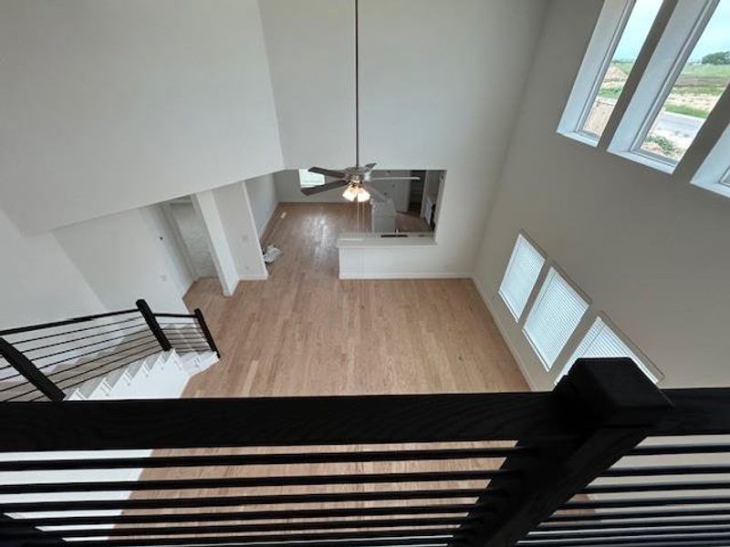 Stairs featuring a high ceiling, a ceiling fan, and wood finished floors