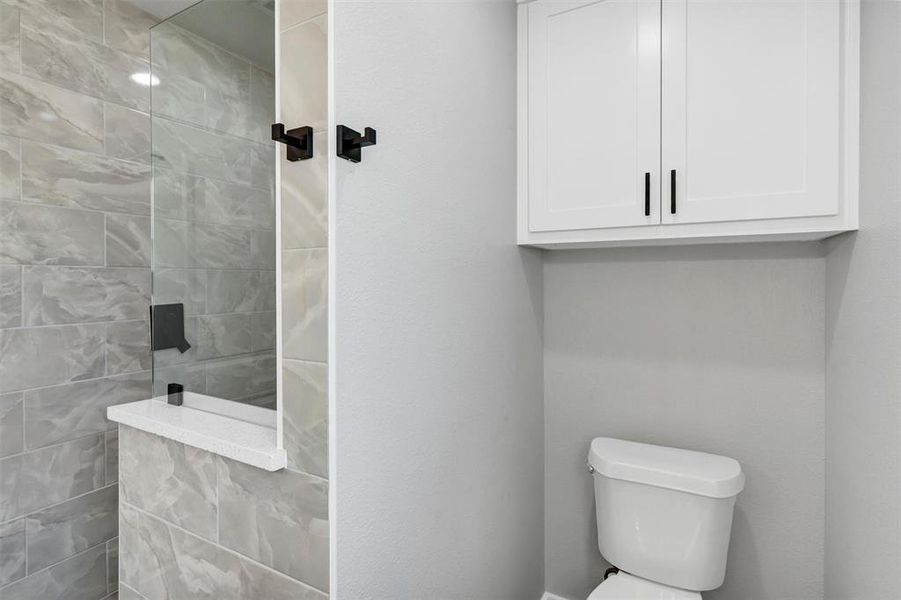 Full bathroom featuring walk in shower and toilet