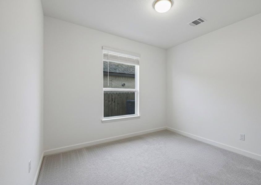 Empty room featuring light carpet and baseboards