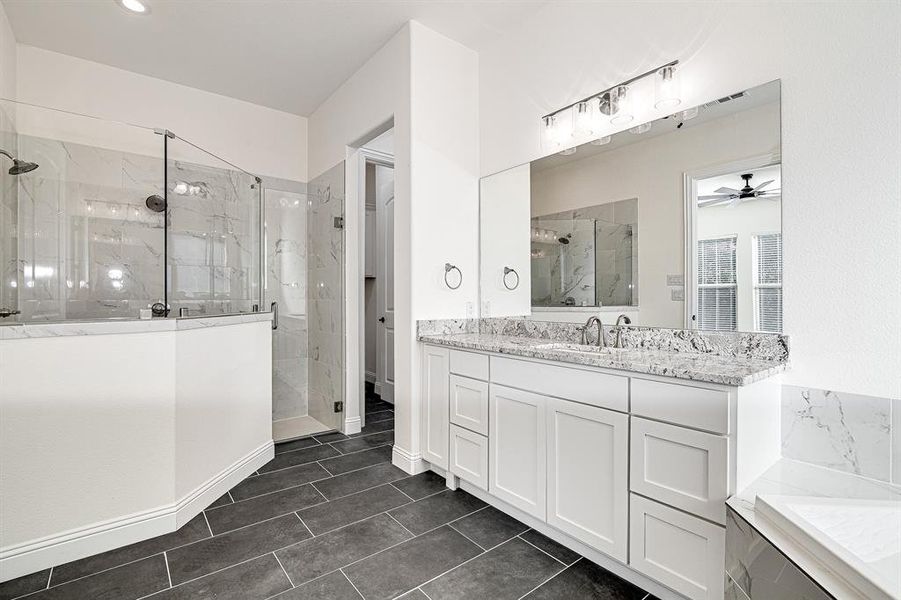 Bathroom featuring plus walk in shower, vanity, and ceiling fan