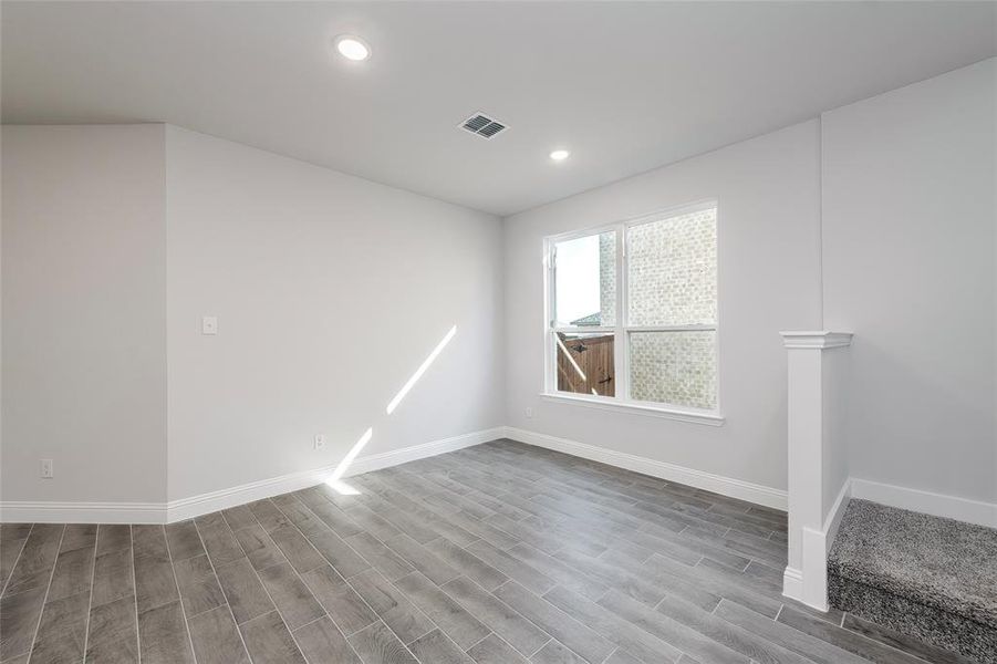 Spare room with baseboards, wood finished floors, and recessed lighting Spare room with baseboards, wood finished floors, and recessed lighting