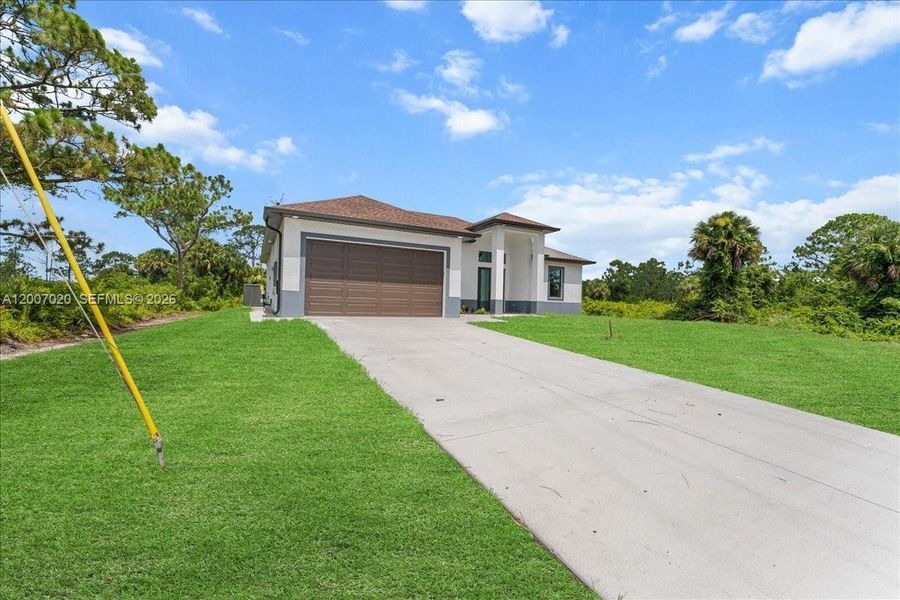 Front exterior of a new home in , Lehigh Acres, FL, highlighting curb appeal (Image 24).