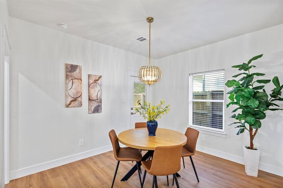 Dining space with hardwood / wood-style flooring and an inviting chandelier