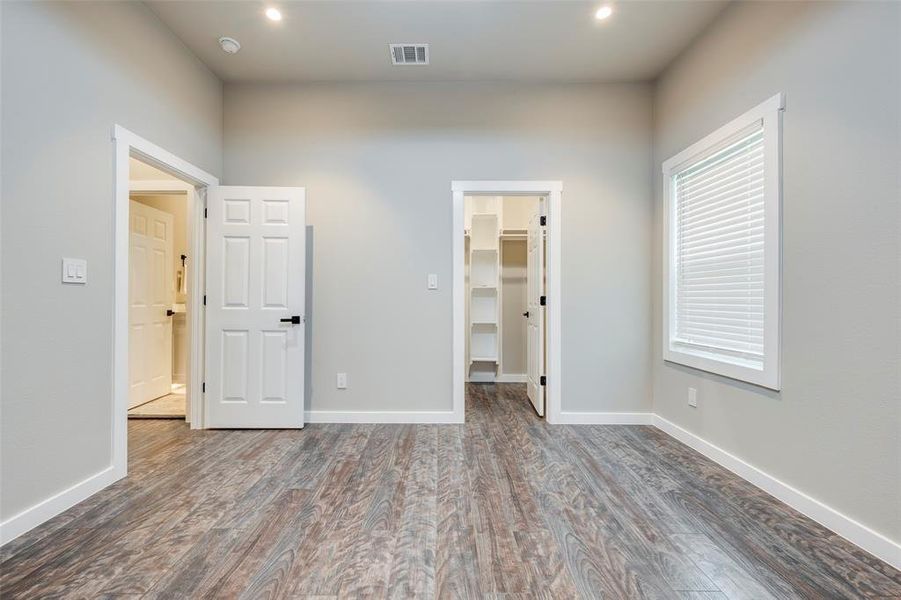 Unfurnished bedroom with wood finished floors, a walk in closet, and recessed lighting