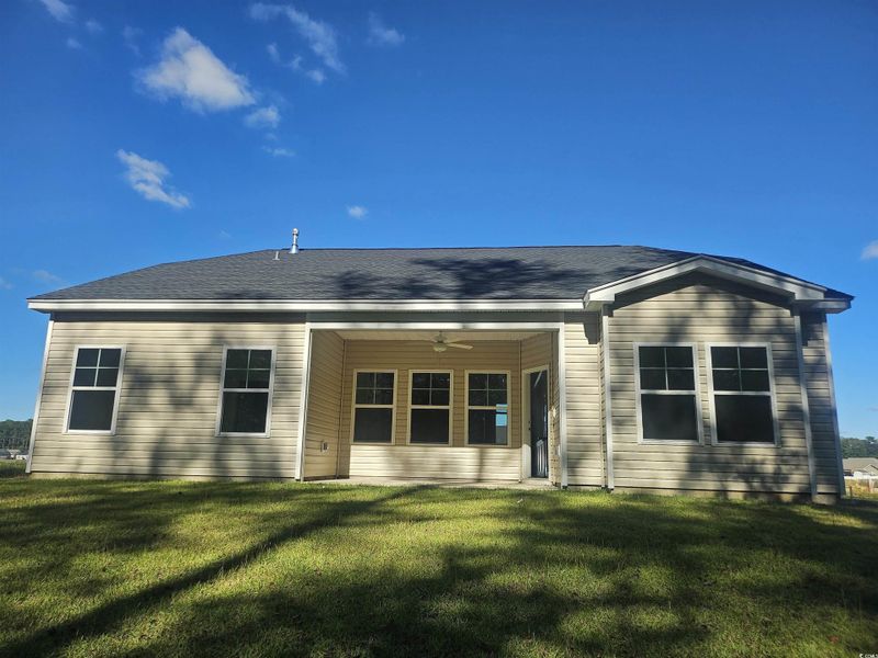 Back of property featuring ceiling fan, a lawn, and a patio area Back of property featuring ceiling fan, a lawn, and a patio area