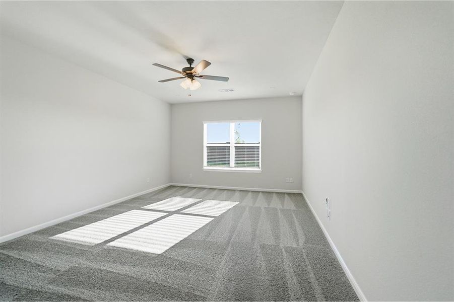 Spacious room featuring neutral painted walls, textured gray carpeting, a multi-pane window with horizontal blinds, and a ceiling fan with integrated lighting Spacious room featuring neutral painted walls, textured gray carpeting, a multi-pane window with horizontal blinds, and a ceiling fan with integrated lighting
