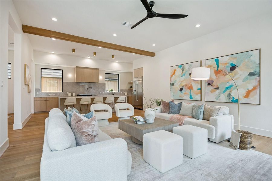 Airy living room features ceiling fan, recessed lighting and wood flooring. Airy living room features ceiling fan, recessed lighting and wood flooring.
