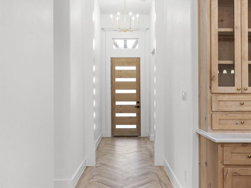 Entryway with baseboards and a chandelier