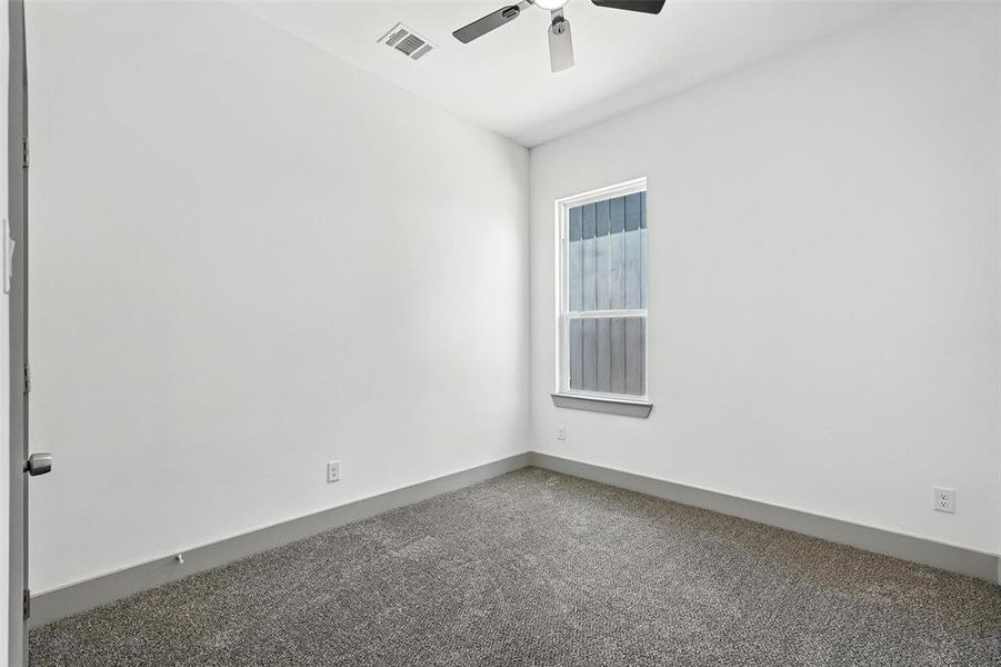 Carpeted empty room featuring baseboards and ceiling fan Carpeted empty room featuring baseboards and ceiling fan