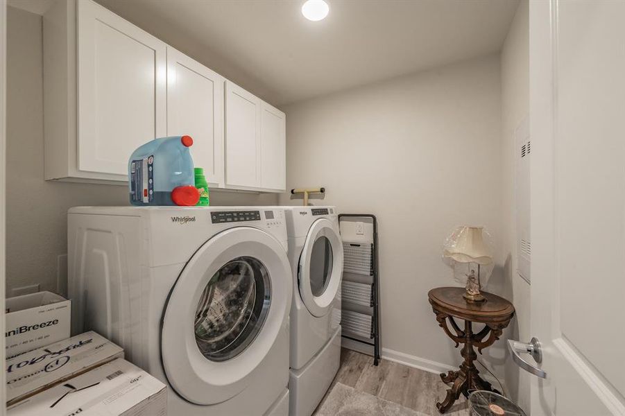 Laundry room with added cabinets offering additional storage.