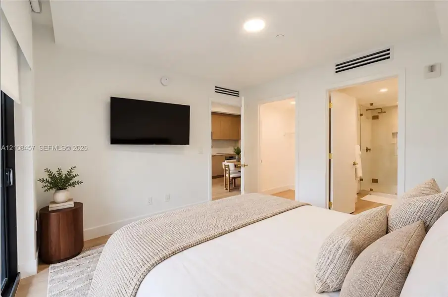 Recessed ceiling lighting, light-toned wood-finish flooring, and minimalist white interior wall finish Recessed ceiling lighting, light-toned wood-finish flooring, and minimalist white interior wall finish