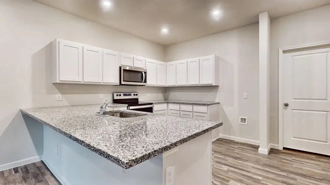A kitchen with white cabinets.