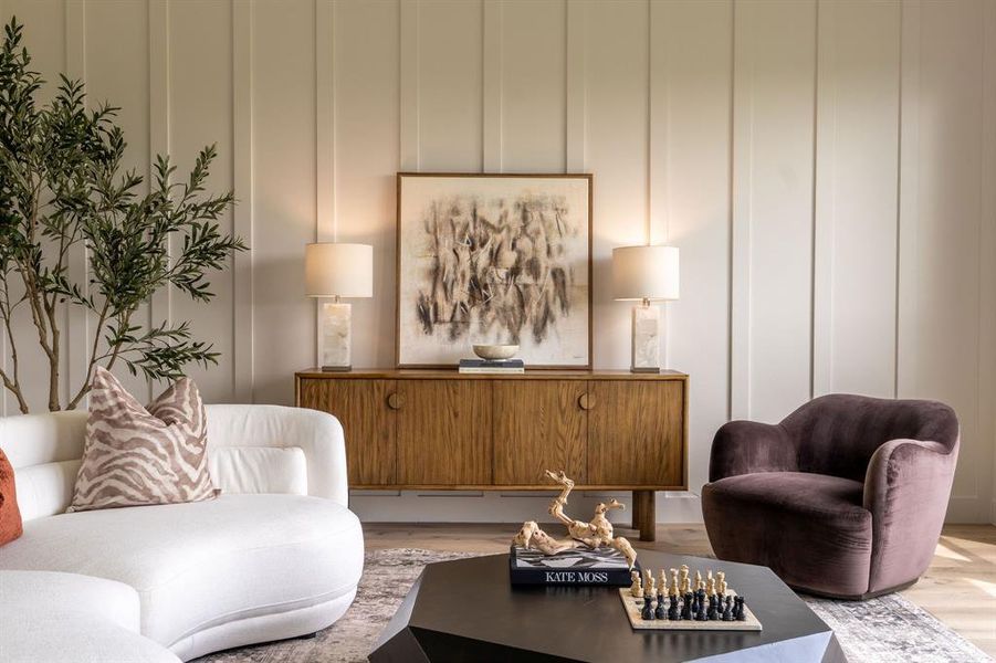 Living room with wood finished floors and a decorative wall Living room with wood finished floors and a decorative wall