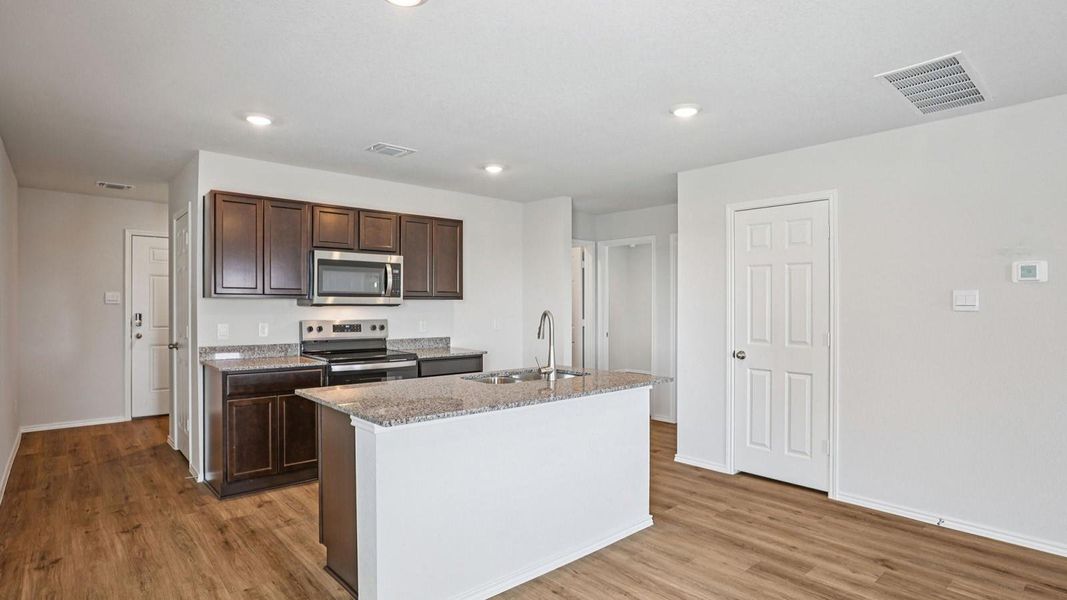 Modern kitchen with granite countertops and stainless steel appliances awaits culinary adventures.