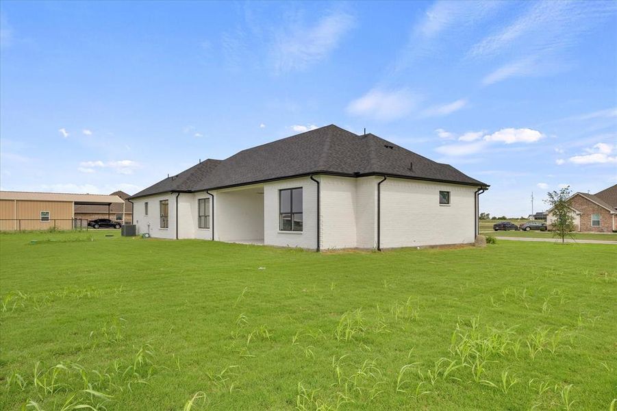 Rear view of property with a yard