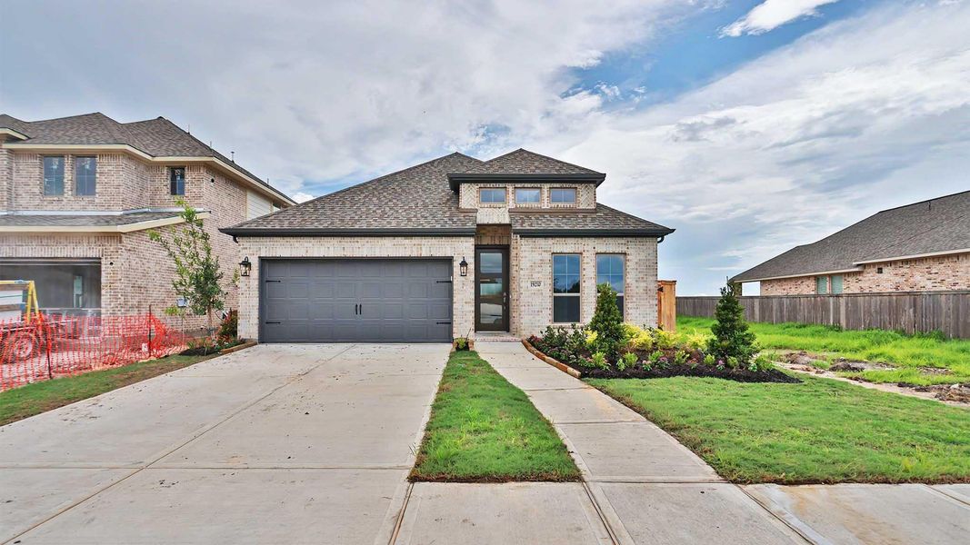 Front exterior of a new home in Valencia, Manvel, TX, highlighting curb appeal (Image 1). Front exterior of a new home in Valencia, Manvel, TX, highlighting curb appeal (Image 1).