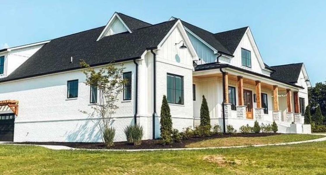 View of property exterior with a porch and a lawn