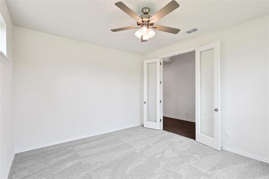 Carpeted empty room with ceiling fan