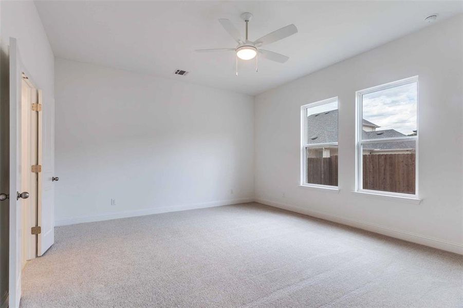 Carpeted empty room with ceiling fan
