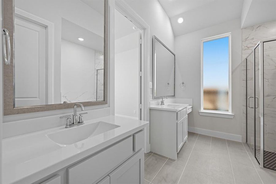 Full bath featuring a marble finish shower, two vanities, light tile patterned floors, and recessed lighting Full bath featuring a marble finish shower, two vanities, light tile patterned floors, and recessed lighting