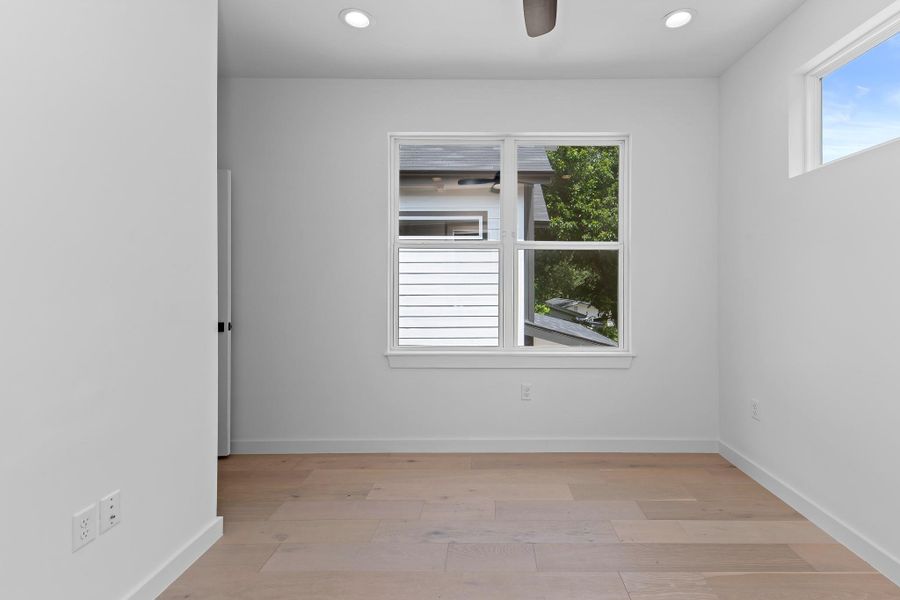 Hardwood floors and generous window lighting create an airy, neutral space ready for your personal touch.