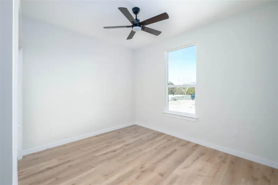 Empty room with light wood-style flooring and a ceiling fan