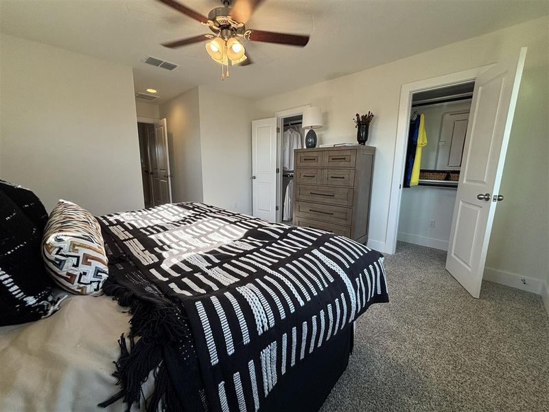 Bedroom with ceiling fan and light carpet