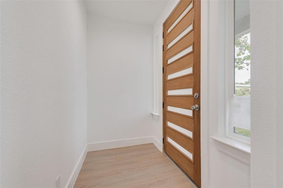 Foyer featuring baseboards and light wood-style floors Foyer featuring baseboards and light wood-style floors