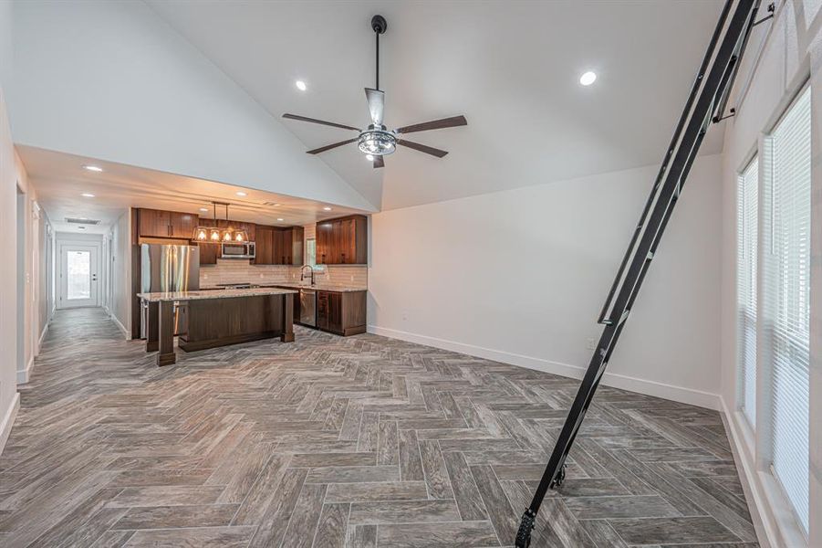 Kitchen with recessed lighting, tasteful backsplash, open floor plan, high vaulted ceiling, and appliances with stainless steel finishes Kitchen with recessed lighting, tasteful backsplash, open floor plan, high vaulted ceiling, and appliances with stainless steel finishes