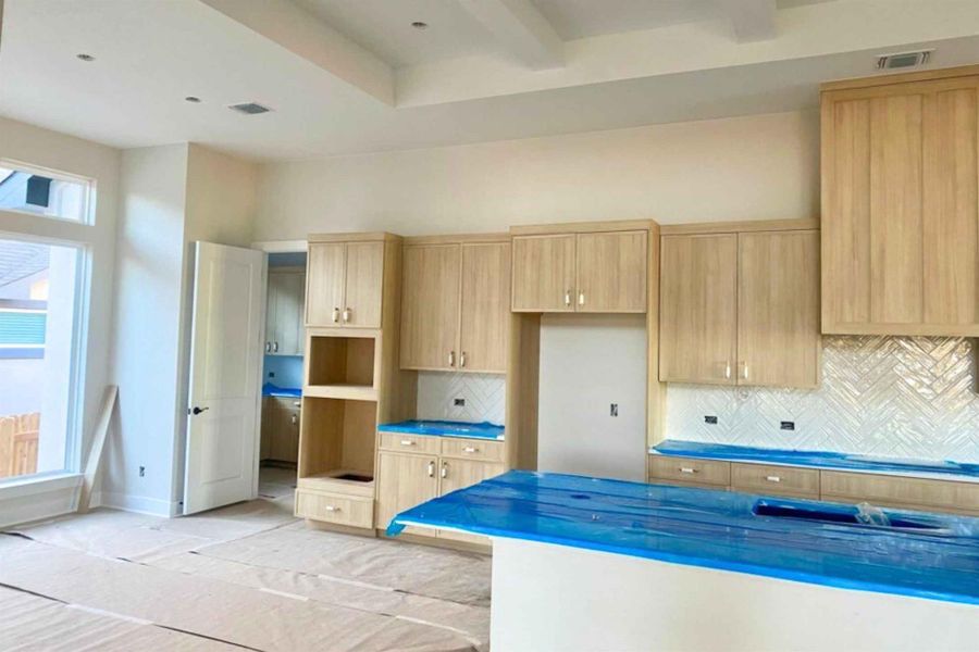 Kitchen featuring light brown cabinets and backsplash