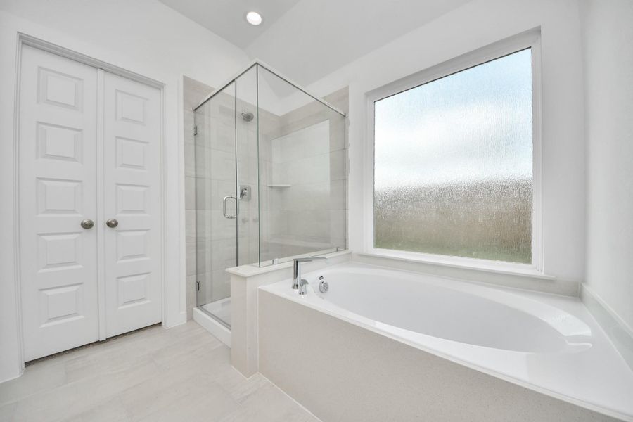 Escape to a spa-like oasis in this primary bathroom. Enjoy a walk-in shower with tile surround, a separate garden tub with custom detailing, and an elegant vanity featuring light countertops, modern hardware, and beautiful recessed lights. Experience luxury and relaxation in every detail. Escape to a spa-like oasis in this primary bathroom. Enjoy a walk-in shower with tile surround, a separate garden tub with custom detailing, and an elegant vanity featuring light countertops, modern hardware, and beautiful recessed lights. Experience luxury and relaxation in every detail.