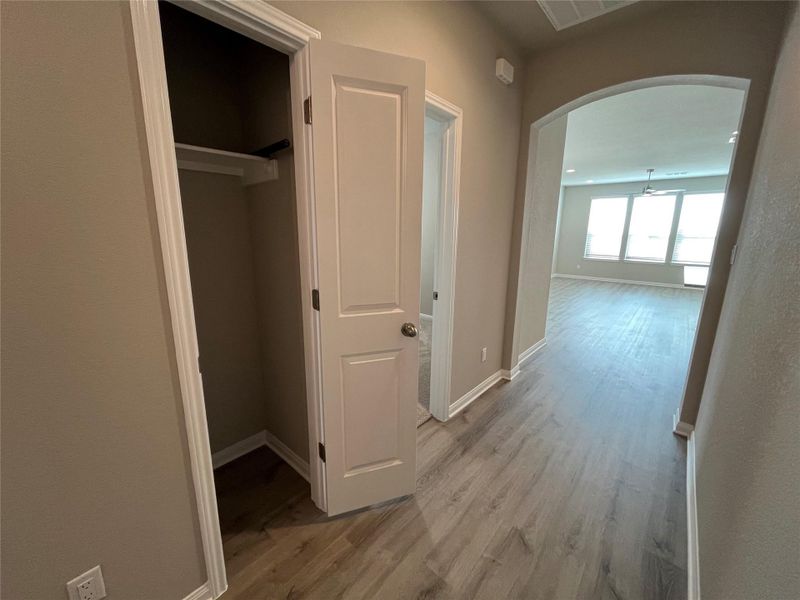 An arched doorway connects the functional hallway storage to the main living space. An arched doorway connects the functional hallway storage to the main living space.