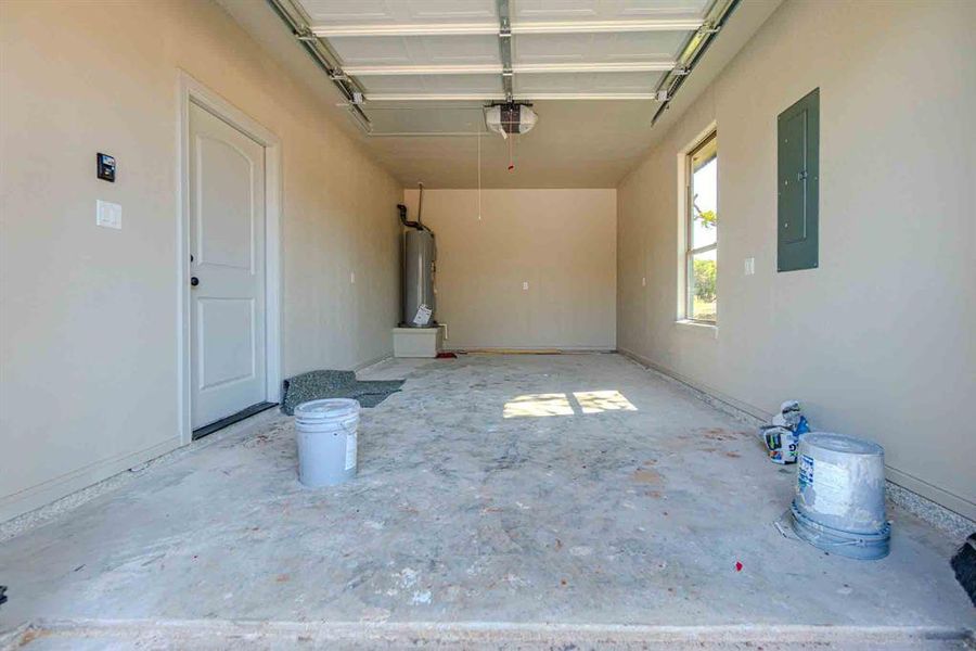 Garage with electric panel, water heater, and a garage door opener
