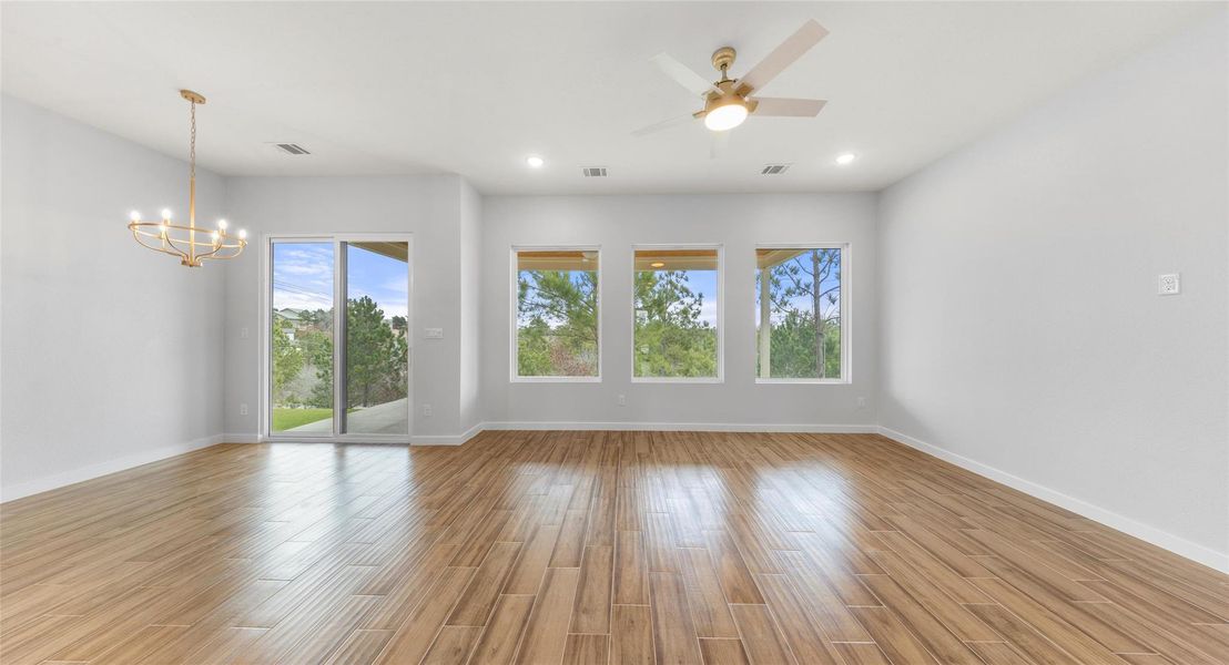 Spare room with ceiling fan, light wood-style floors, a chandelier, and recessed lighting