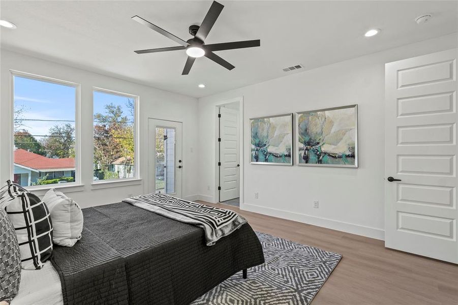 Bedroom with access to exterior, light hardwood / wood-style floors, and ceiling fan