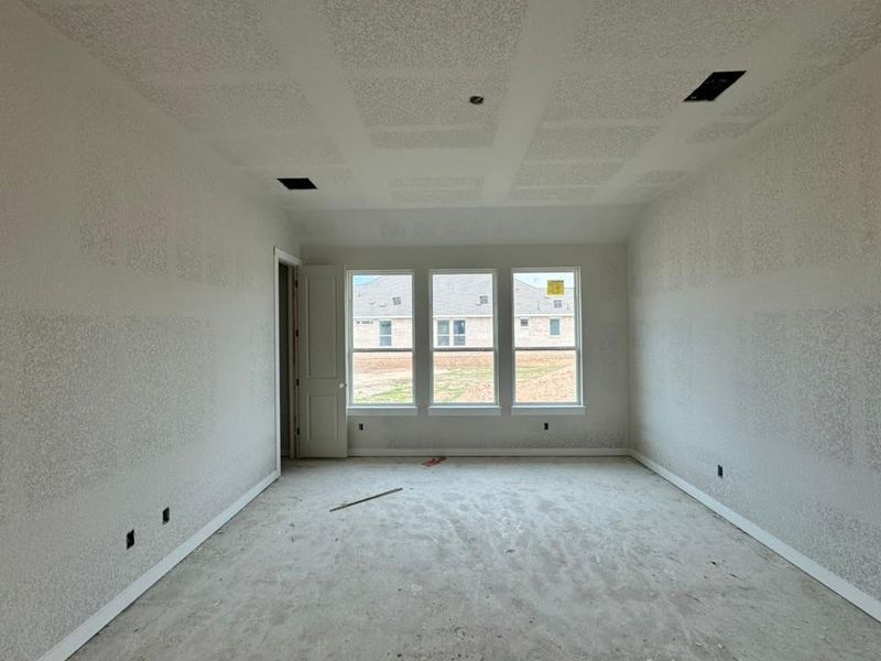 Spare room with a textured wall and baseboards